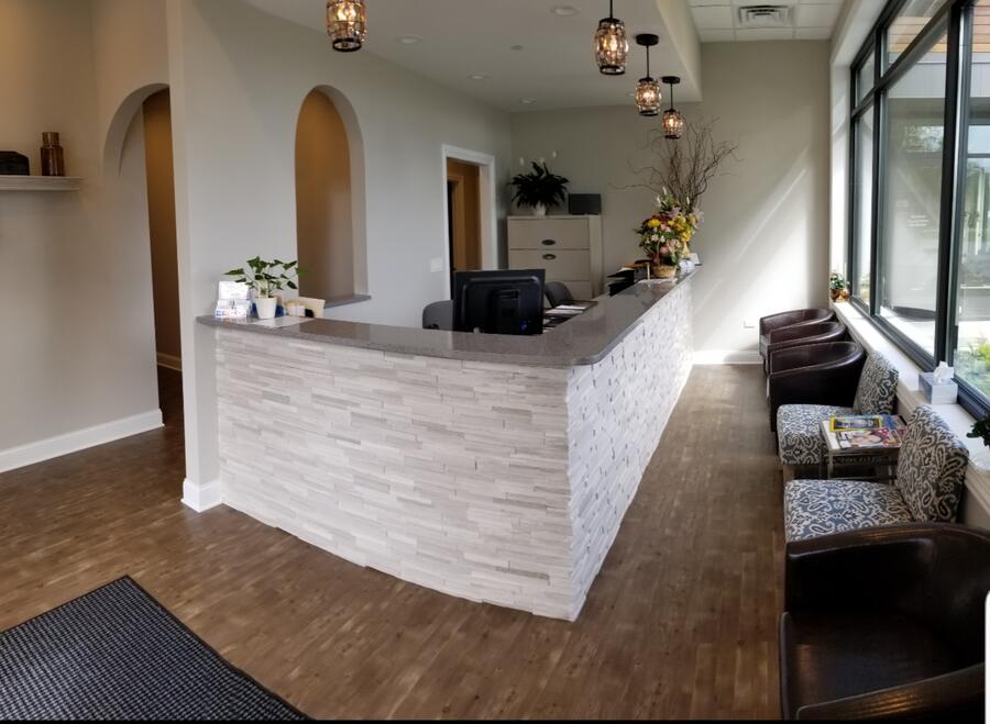 Finished reception with stone-front desk, arched entries, and pendant lighting