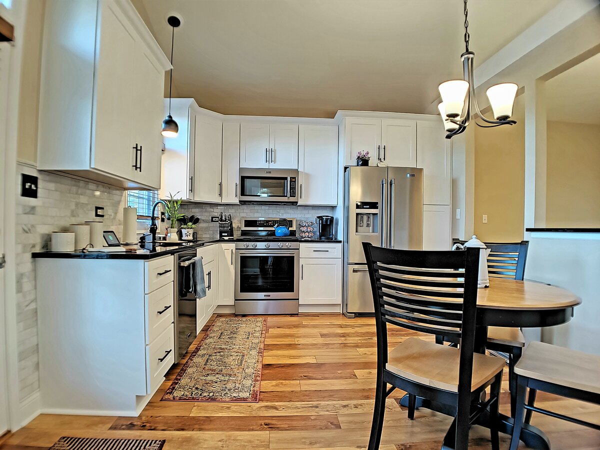 Bright white shaker kitchen remodel with hardwood floors by Alpha Development Group